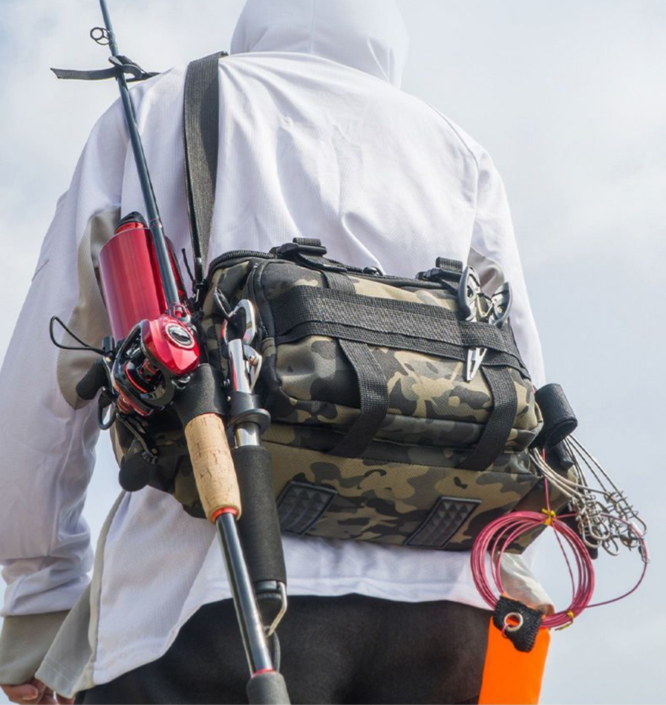 Fisherman carrying Nice Bags camo tackle bag with attached fishing rod outdoors
