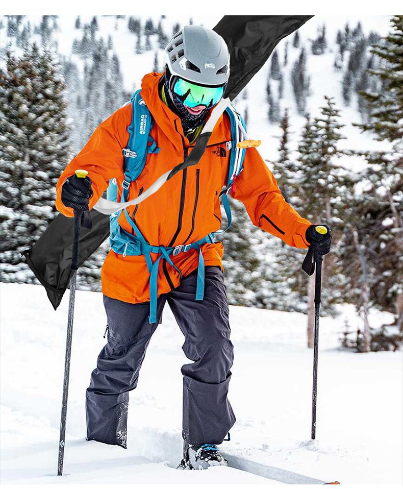 Skier carrying Nice Bags black adjustable ski bag with white webbing on snow mountain slope