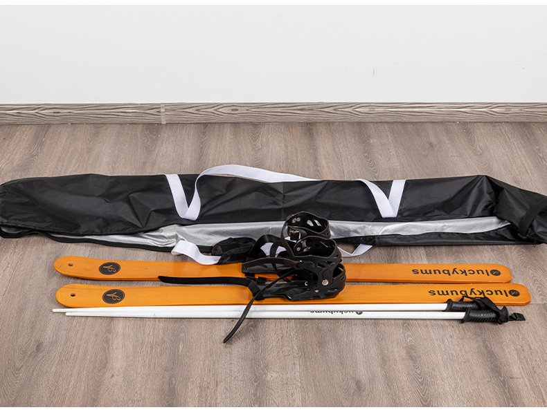 Nice Bags opened black ski bag laid flat with pair of wooden skis and ski poles