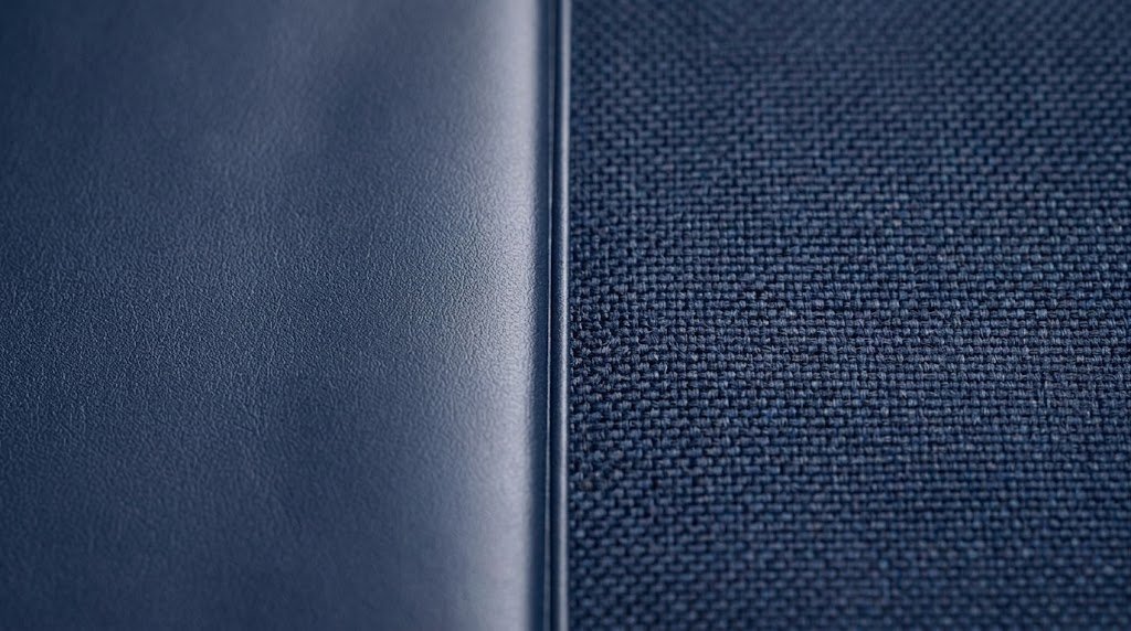 Close-up texture comparison of smooth PU leather versus woven Oxford fabric, showing why bag branding techniques suit different materials