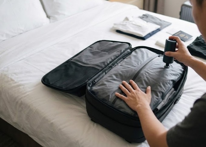 Compressing a travel vacuum compression backpack with an electric pump while packing