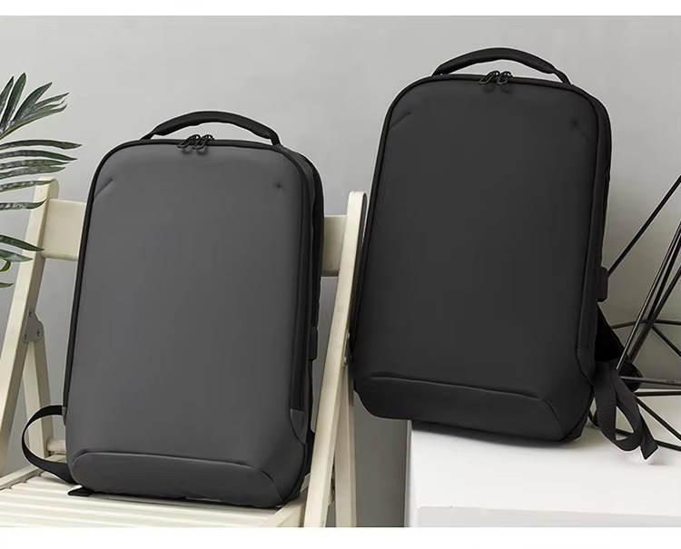 gray and black backpack shown side by side on a chair