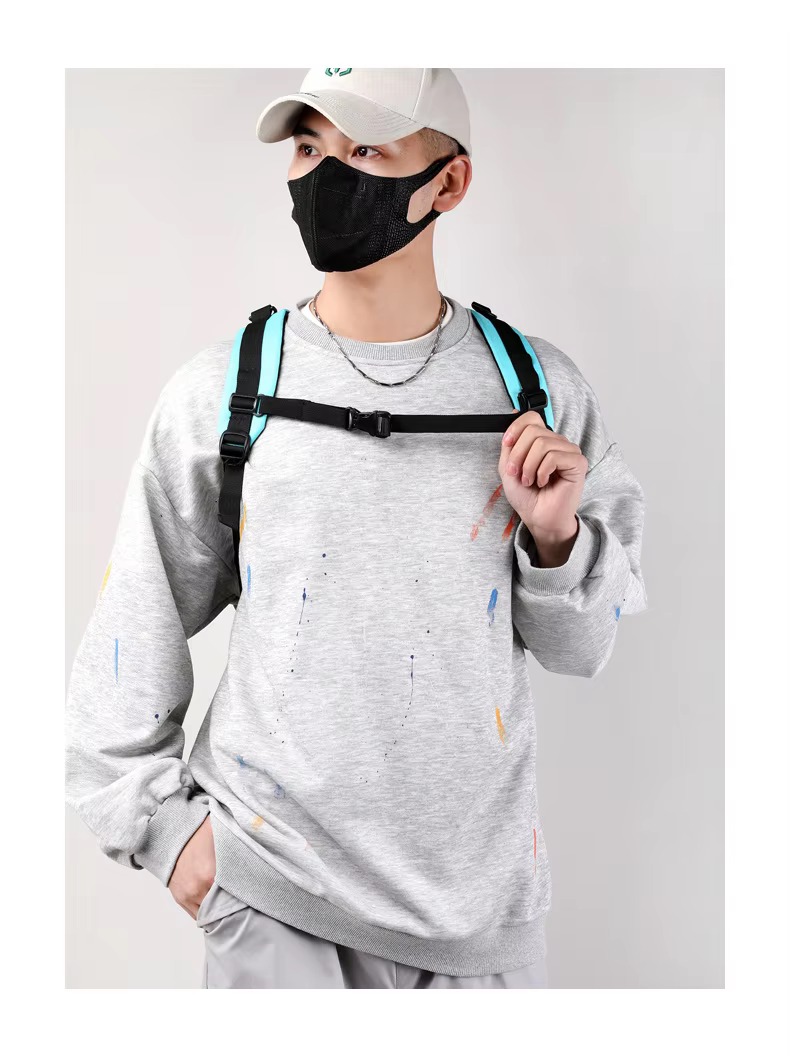 model wearing teal backpack with chest buckle fastened, looking aside