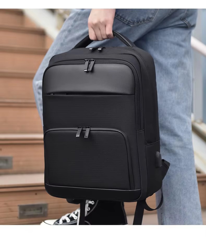 man carrying the backpack by its top handle on stairs