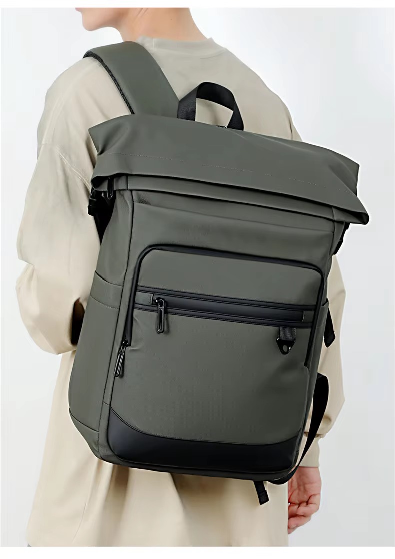 man wearing olive green rolltop backpack from behind