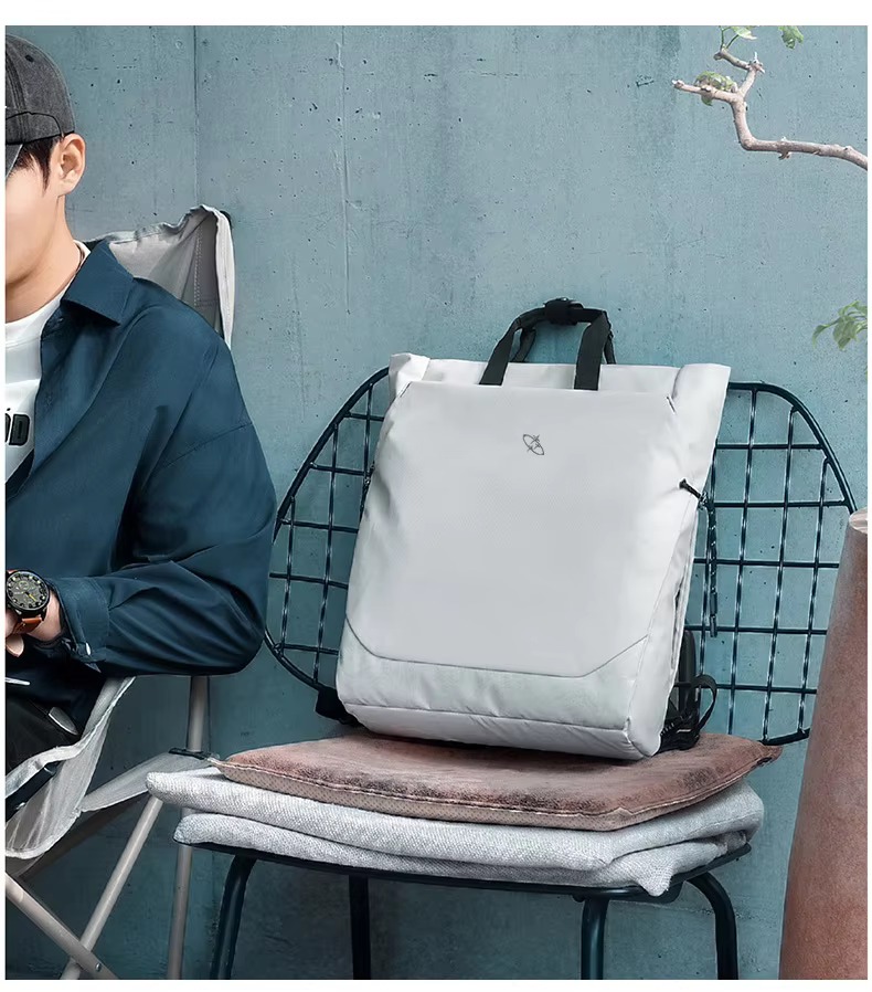 white backpack resting on wire chair lifestyle shot