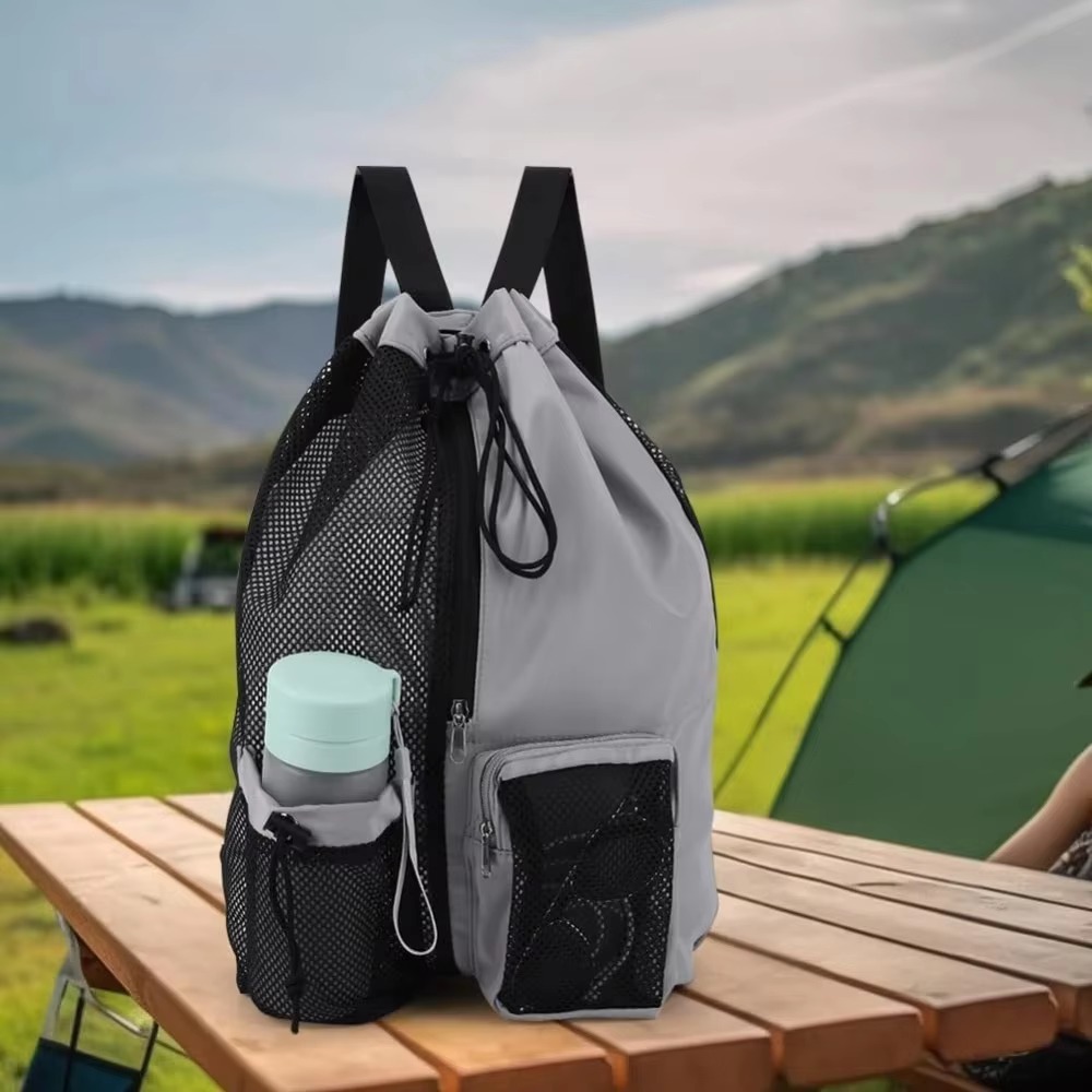 gray and black mesh backpack on a picnic table with water bottle
