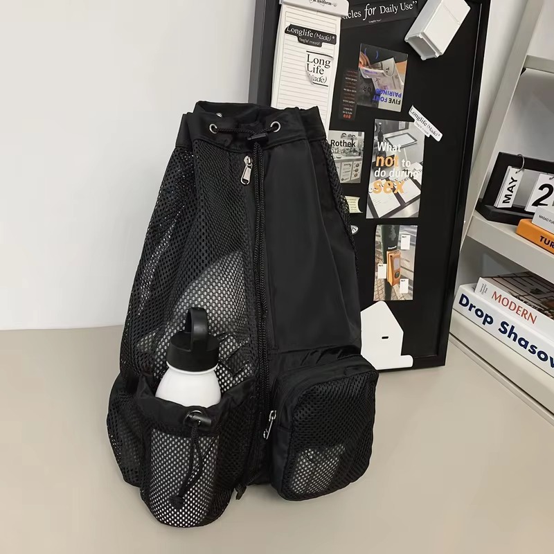 open bag packed with clothing, books, and a phone