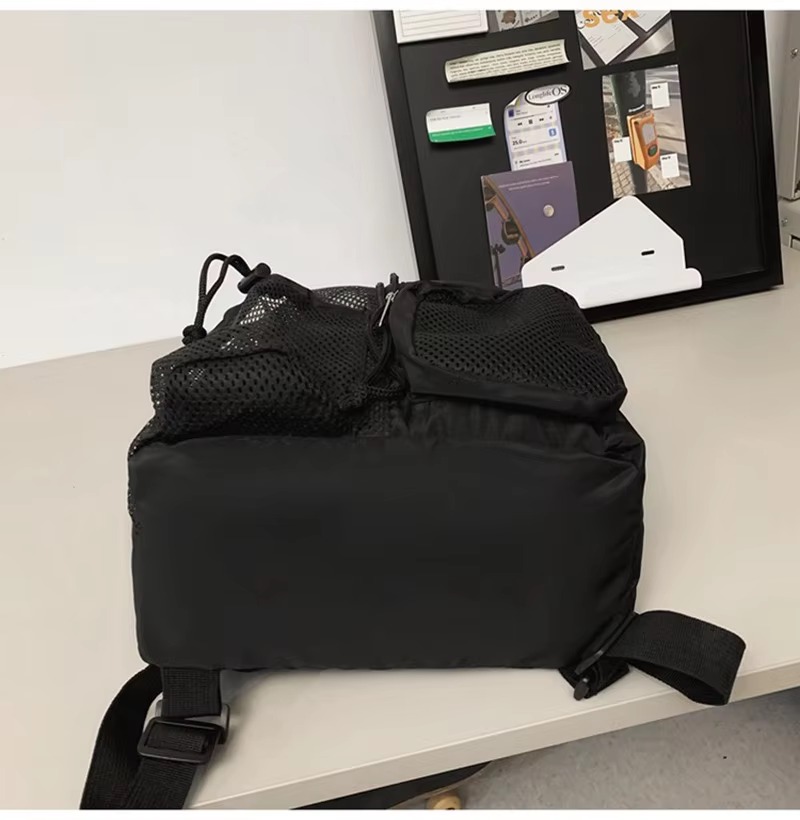 black backpack packed and laid on its side showing bottom mesh panel