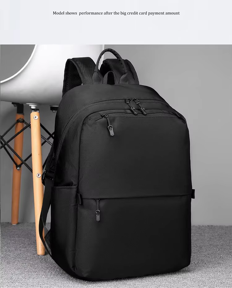 black backpack worn on one shoulder beside a chair