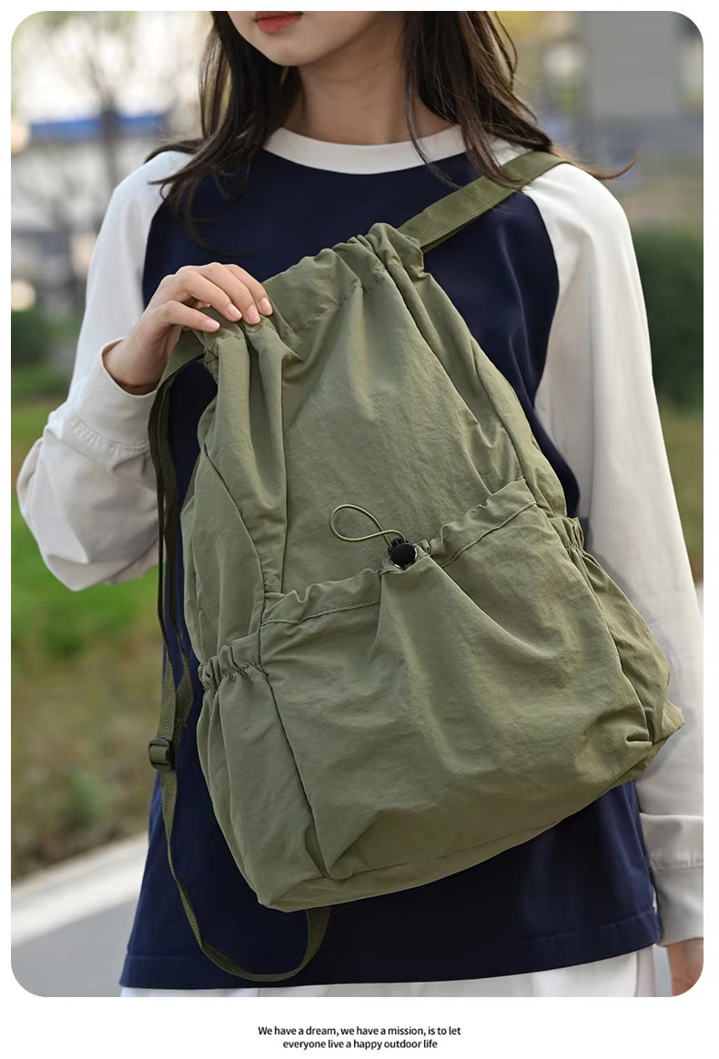 woman holding green backpack strap