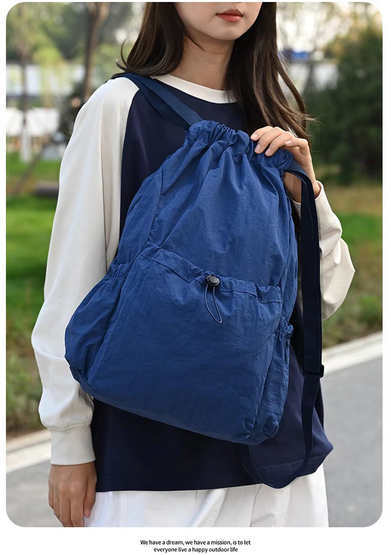 woman holding blue backpack