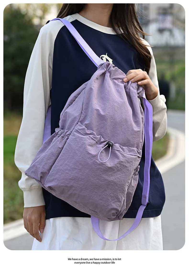 woman holding purple backpack
