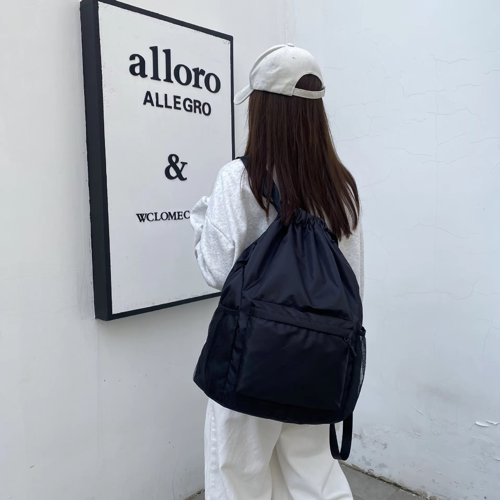 woman wearing black backpack back view