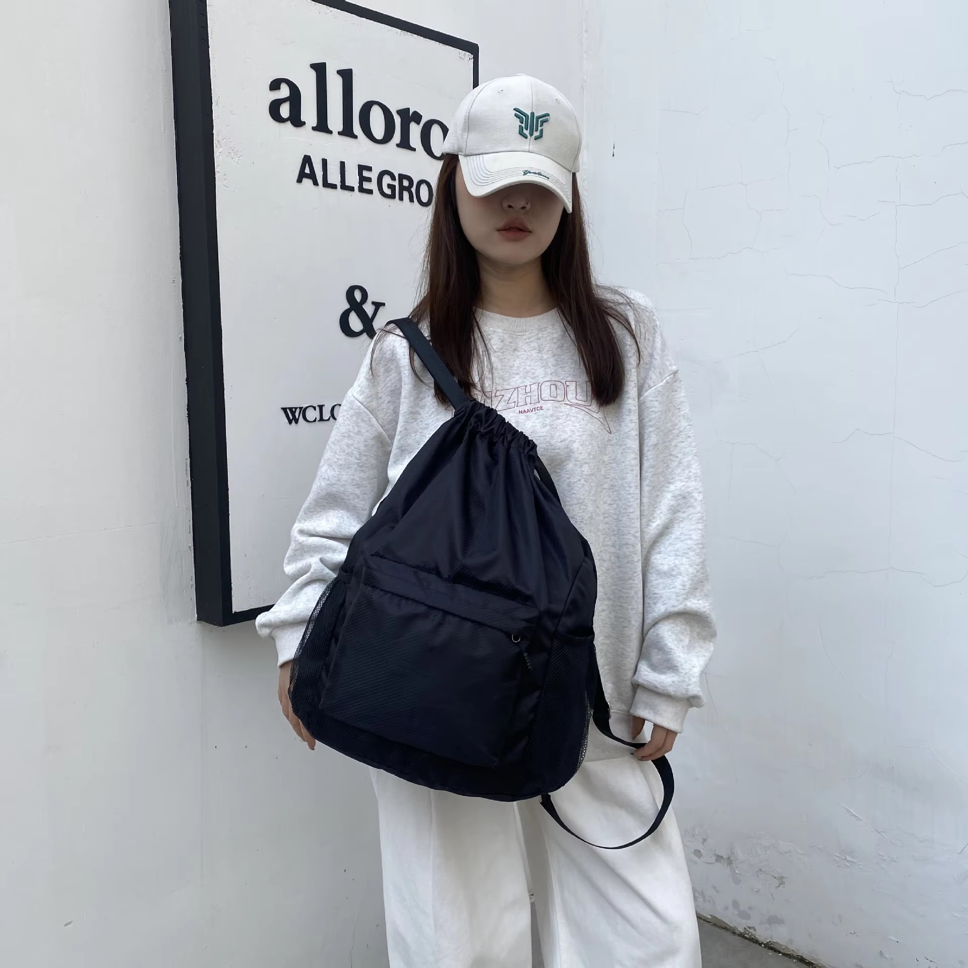 woman holding black backpack on one shoulder