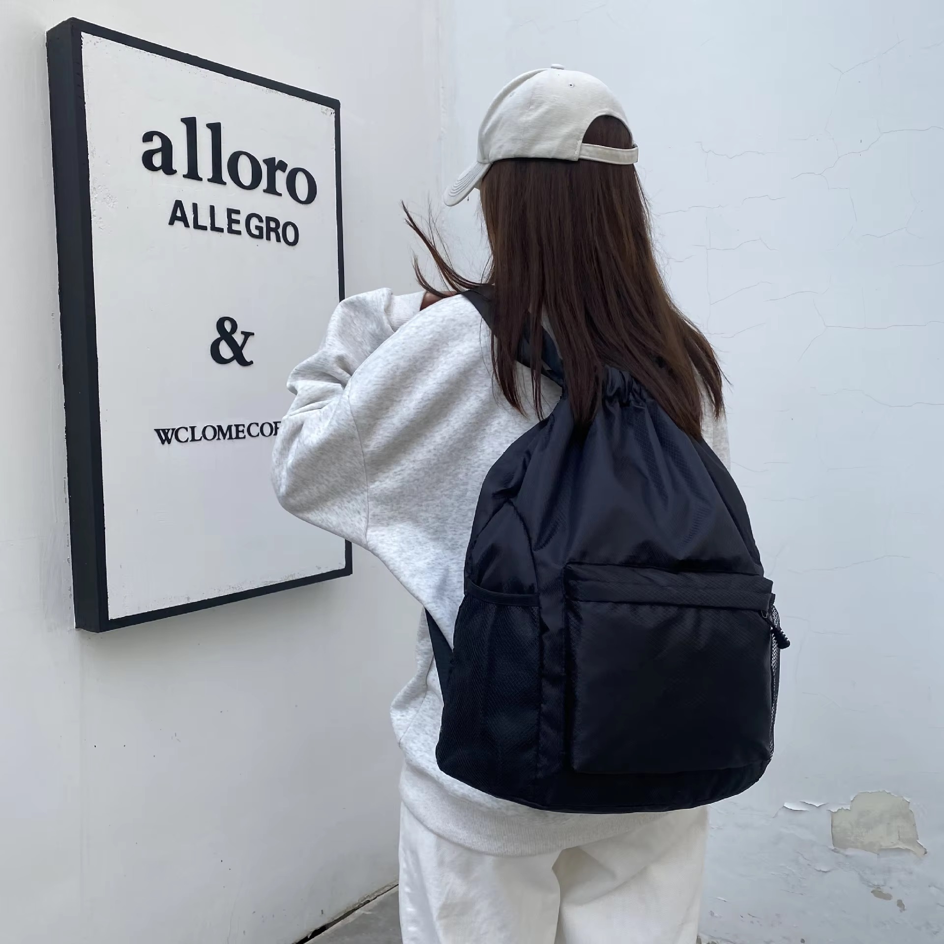woman wearing black backpack rear angle
