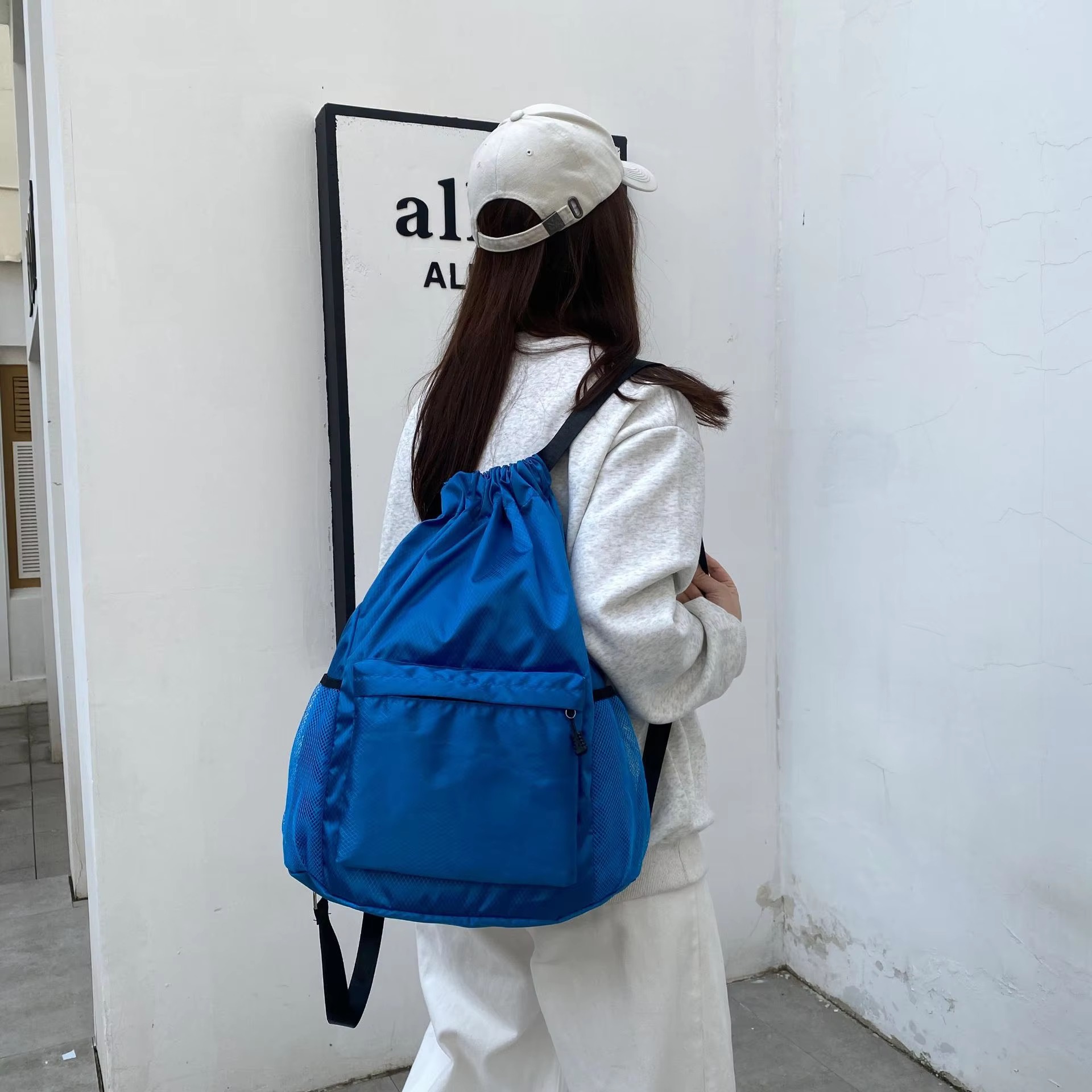 woman wearing royal blue backpack side