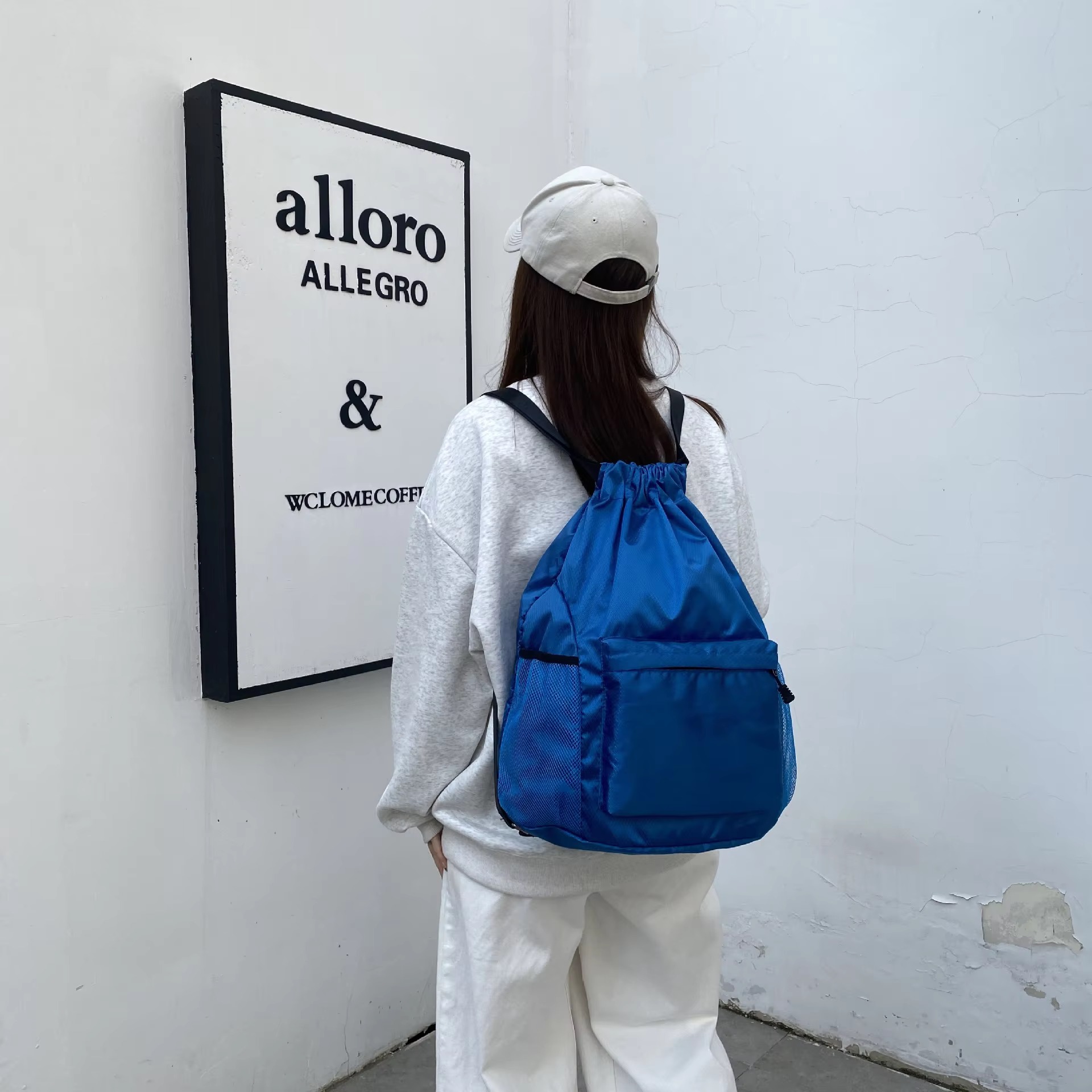 woman wearing blue backpack back view