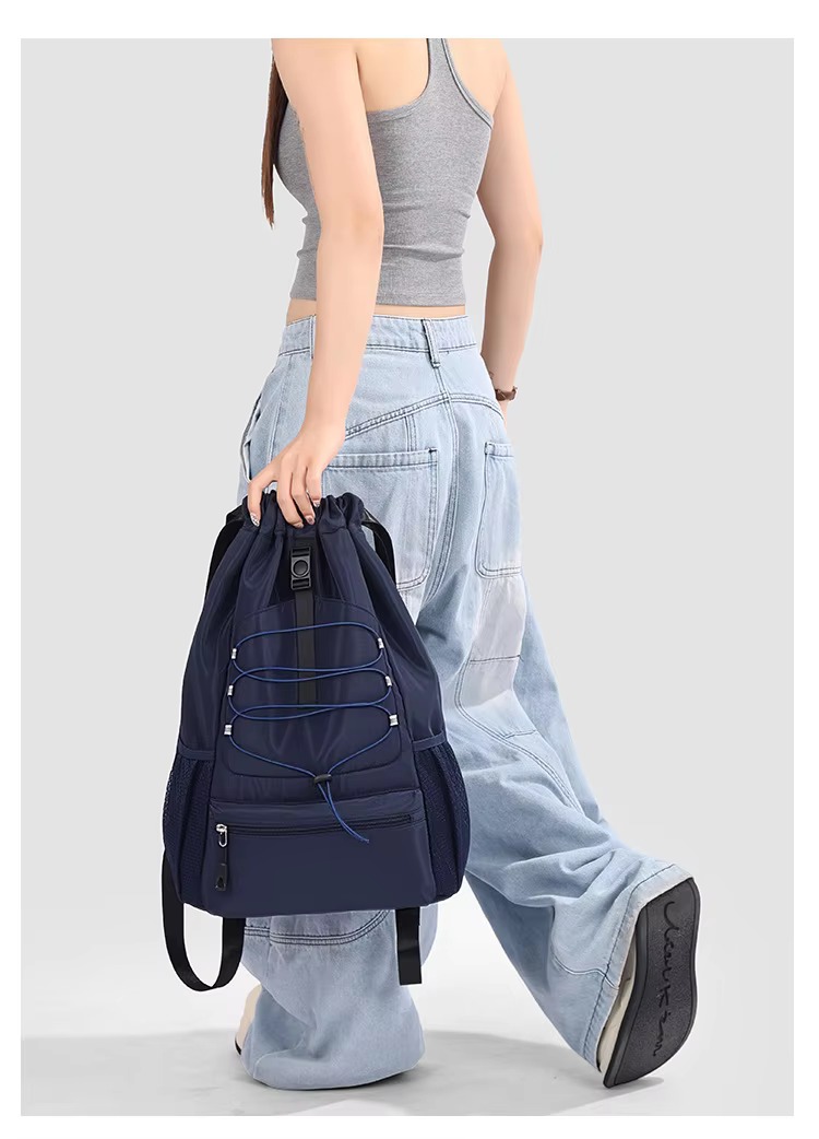 woman carrying dark blue backpack by hand