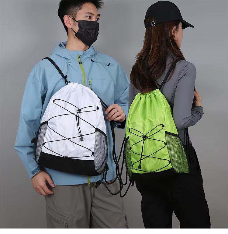 couple holding white and green backpacks