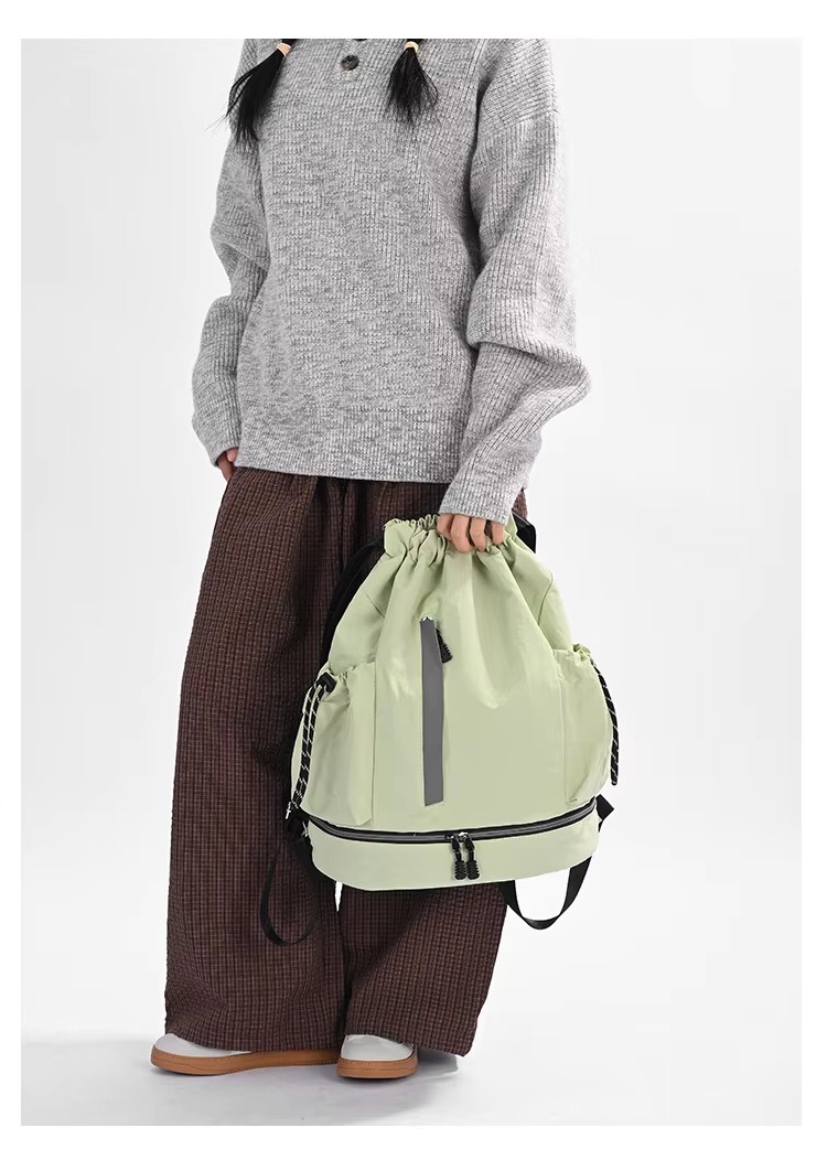 woman holding green backpack