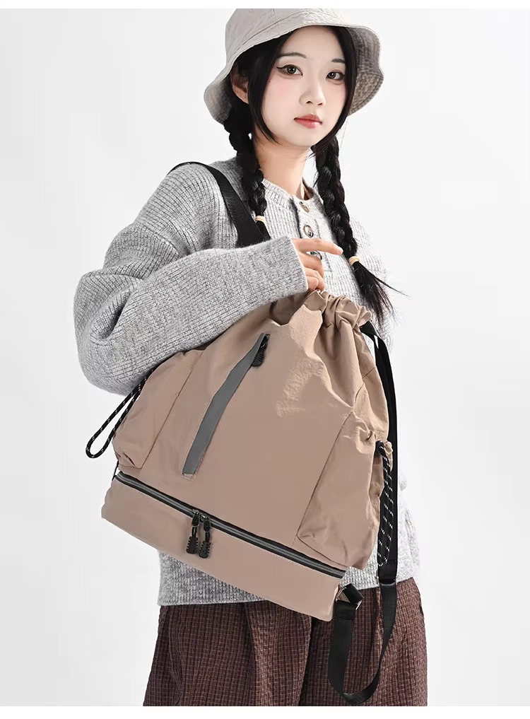 woman holding khaki backpack