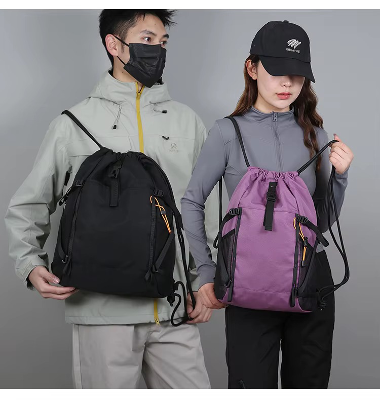 couple holding black and purple backpacks