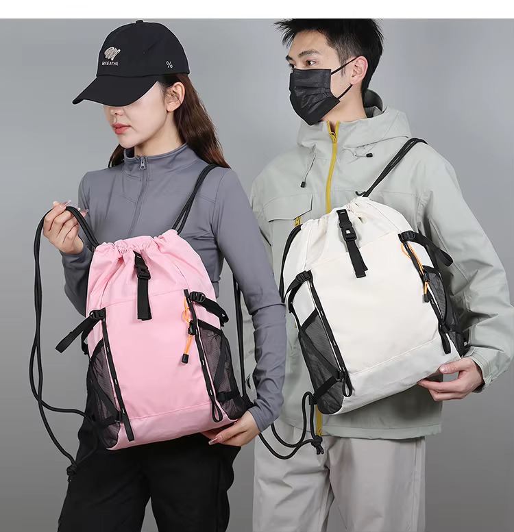 couple holding pink and beige backpacks