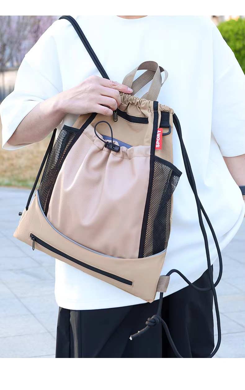 man holding khaki backpack