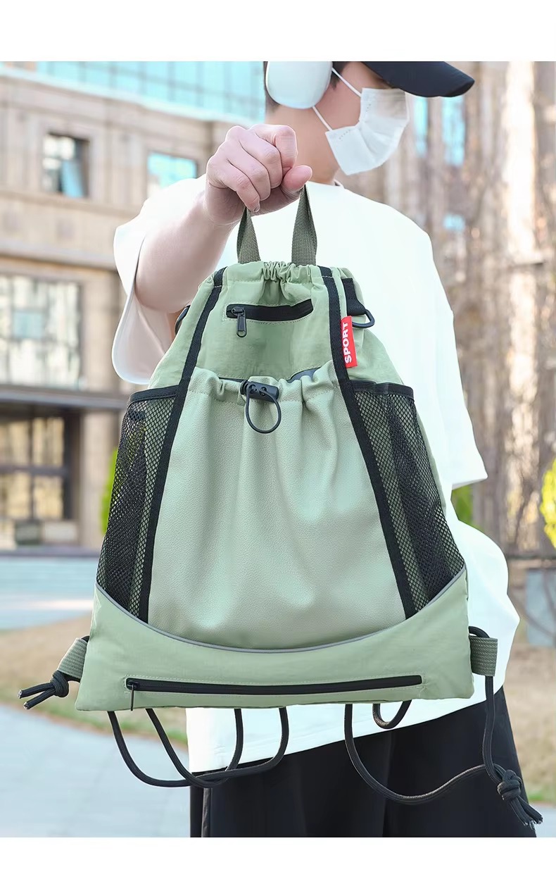 man holding green backpack