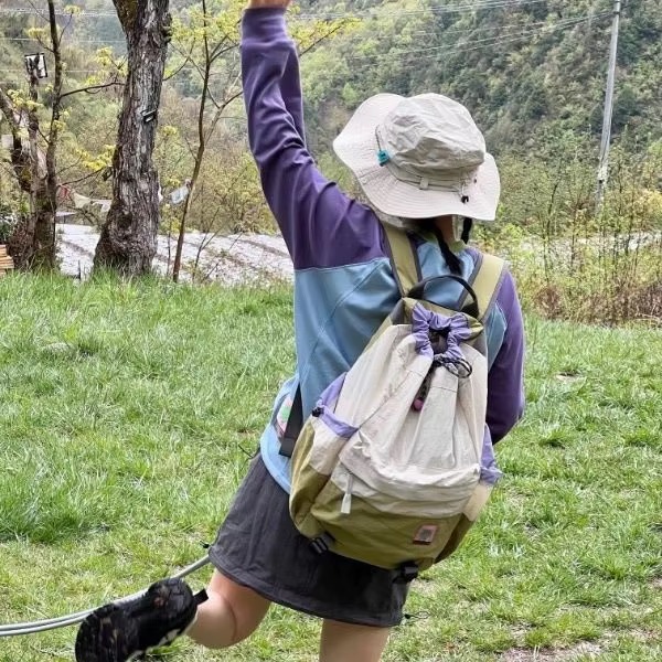 woman hiking with beige and green backpack