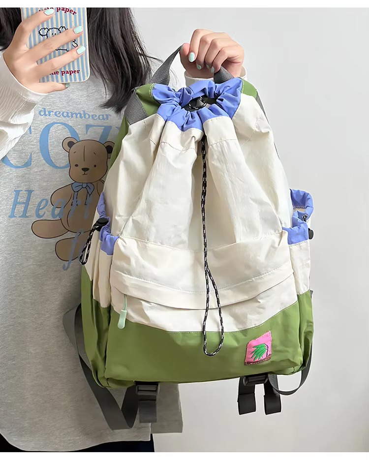 student holding beige backpack by handle