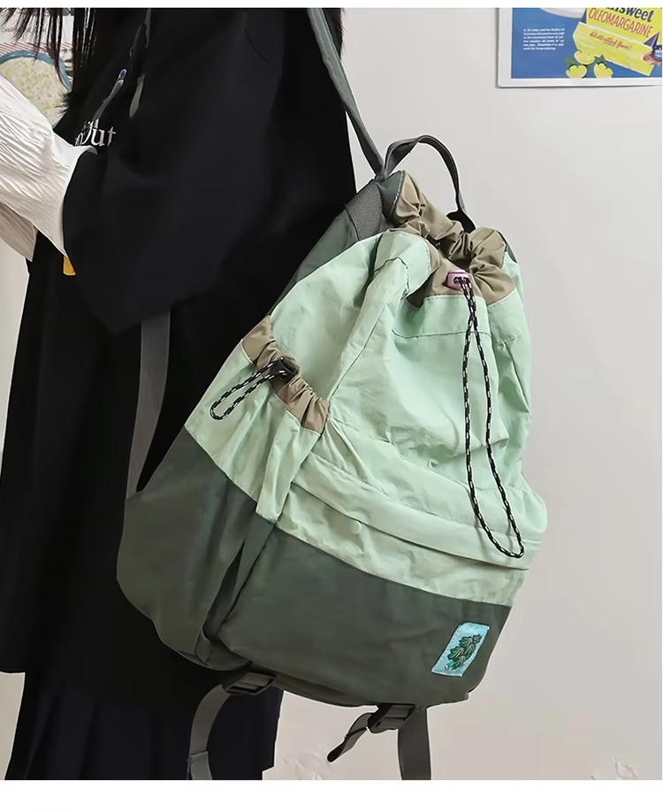 green backpack carried on one shoulder