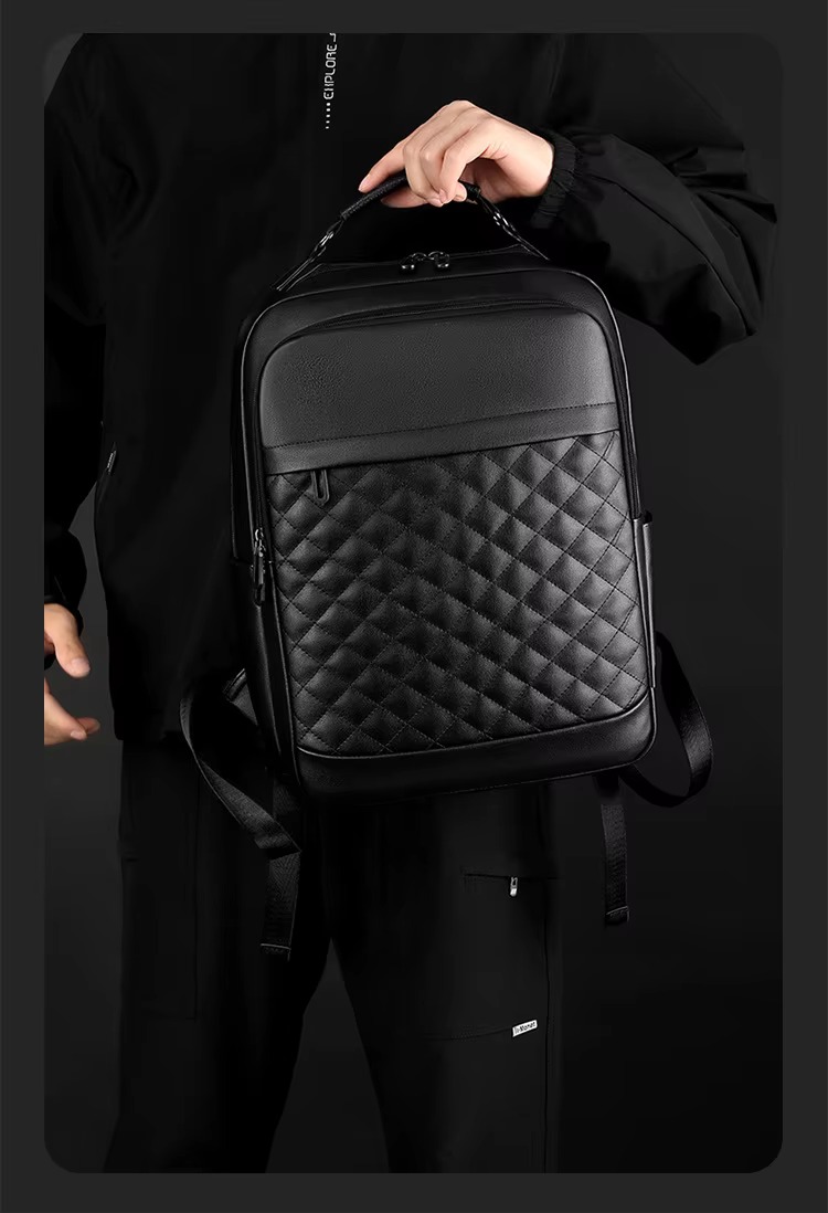man carrying backpack by handle
