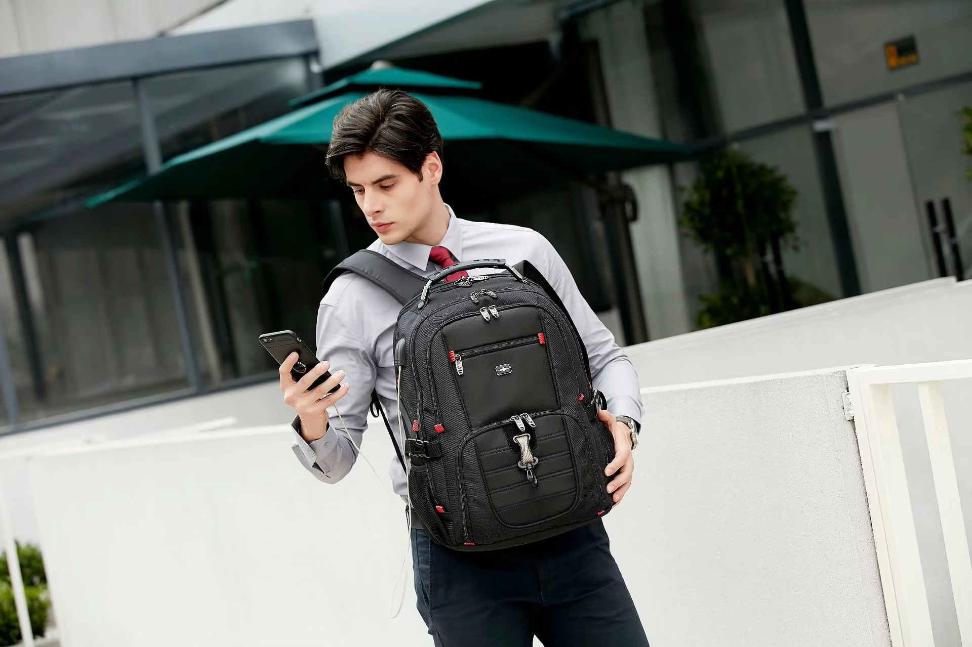 man checking phone while wearing backpack