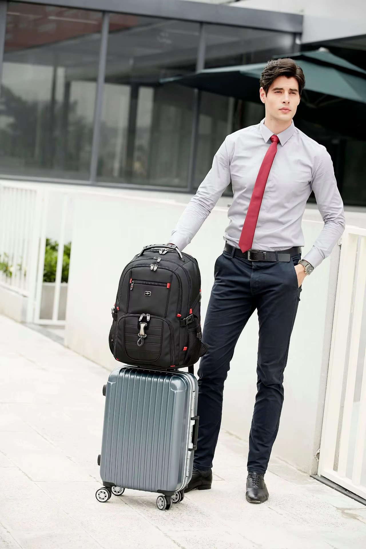 backpack on trolley case beside man