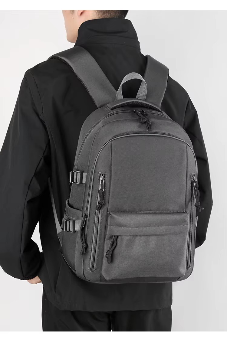 man wearing gray backpack back view