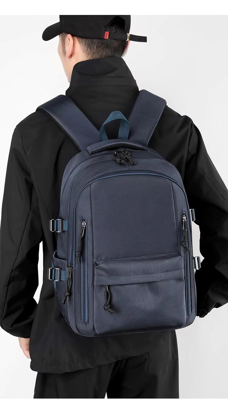 man wearing dark blue backpack back view