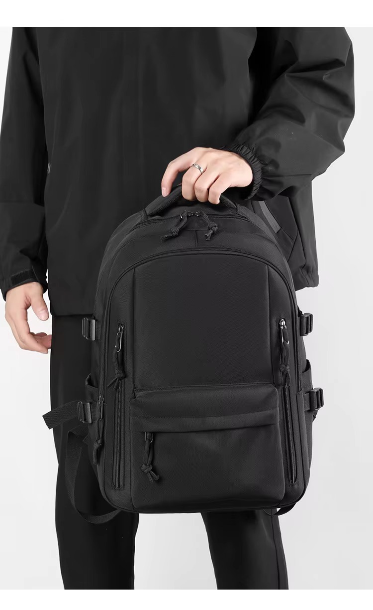 man holding black backpack by handle
