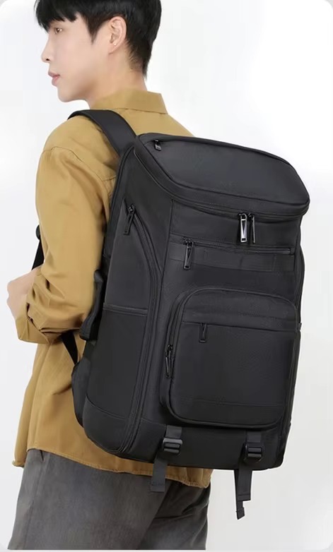 man wearing black backpack side view