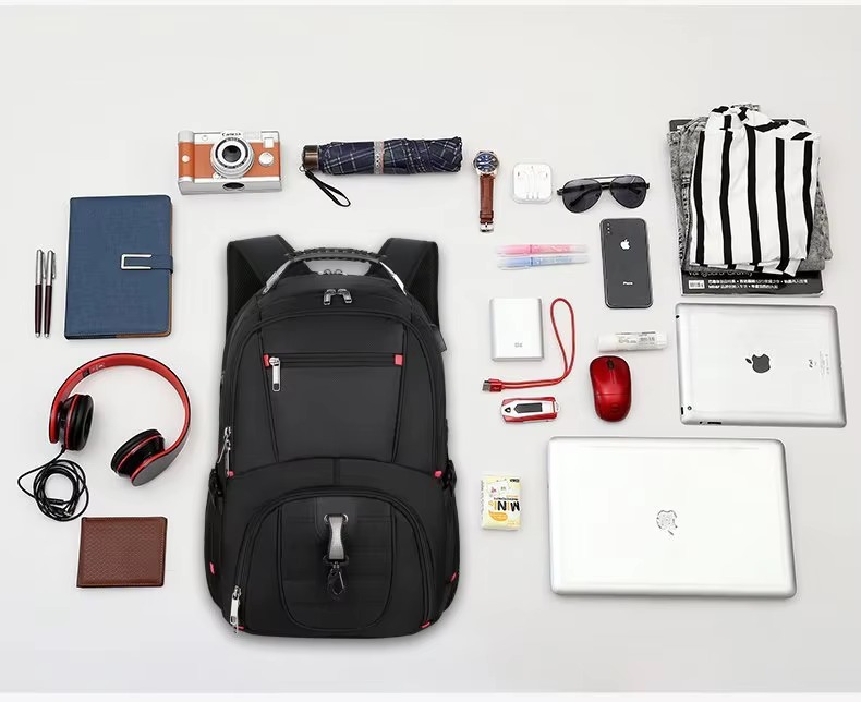 flat lay of backpack with laptop camera and travel accessories