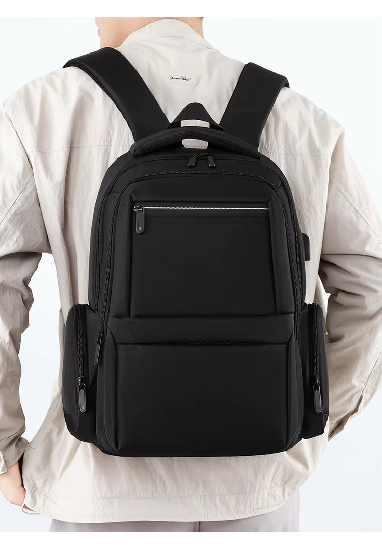 man wearing black backpack back view
