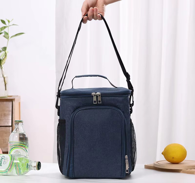 navy blue bag held by top handle with shoulder strap