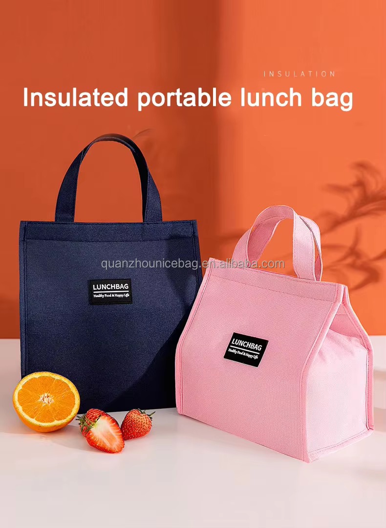 navy and pink lunch bags beside fresh orange and strawberries
