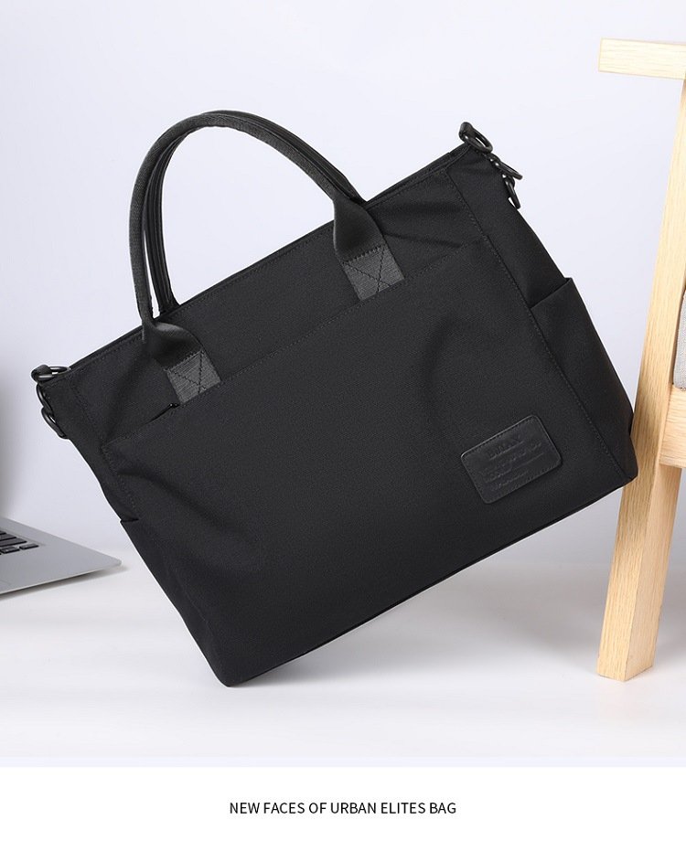bag propped against wooden chair beside open laptop showing urban elites styling