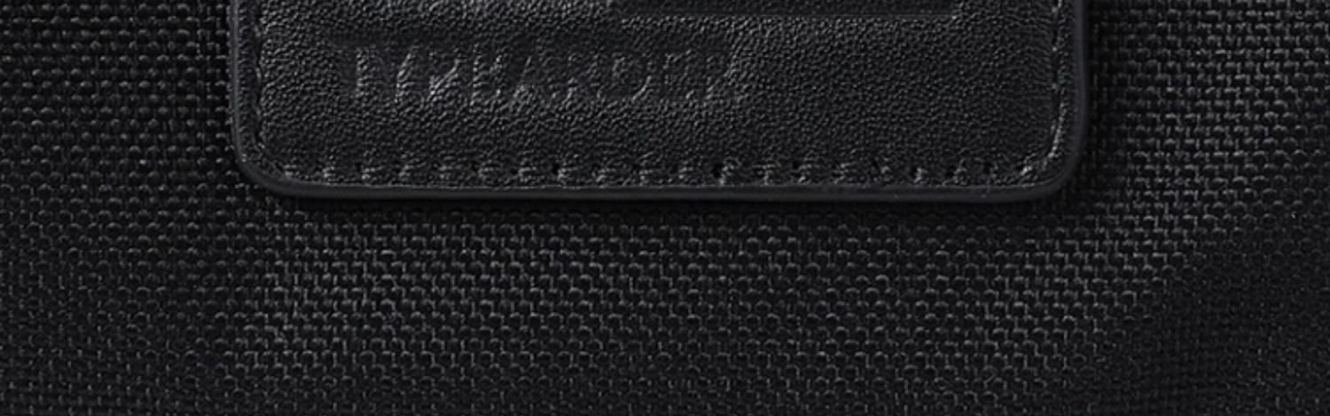 reinforced padded handle close-up showing top-grain leather and nylon webbing construction