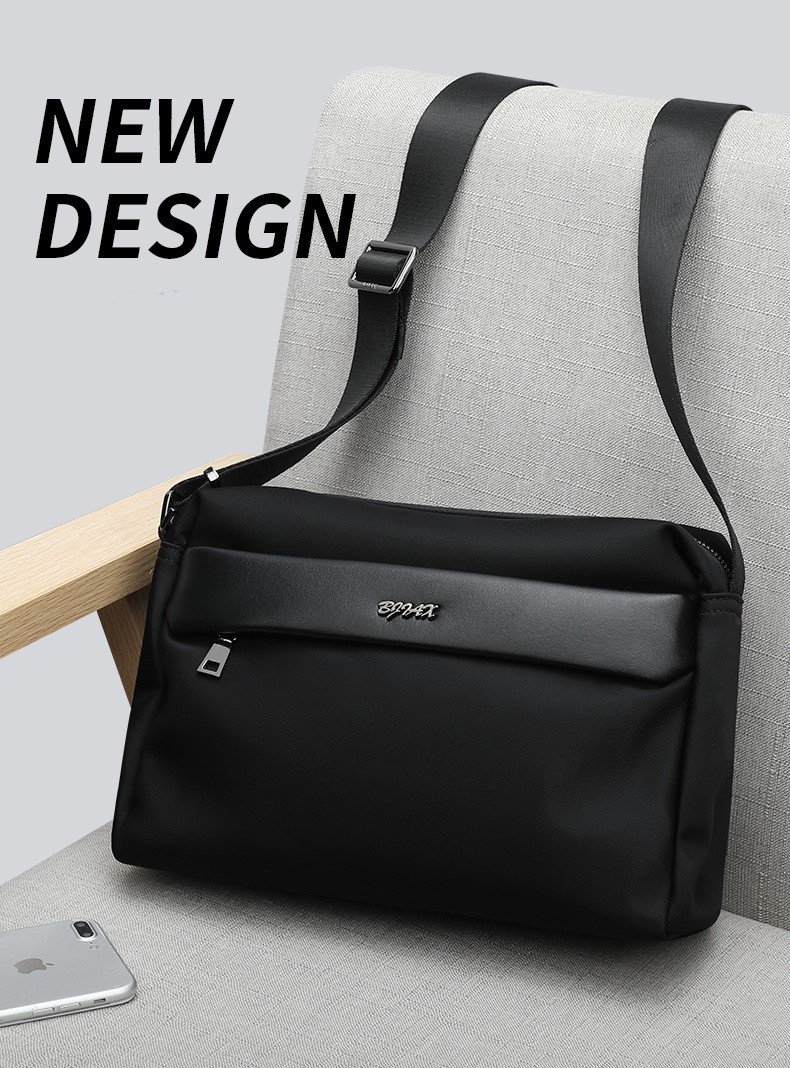 black bag resting on gray armchair beside phone and sunglasses