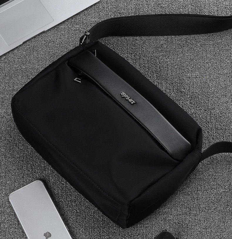 overhead angled view of bag on carpet next to phone and laptop
