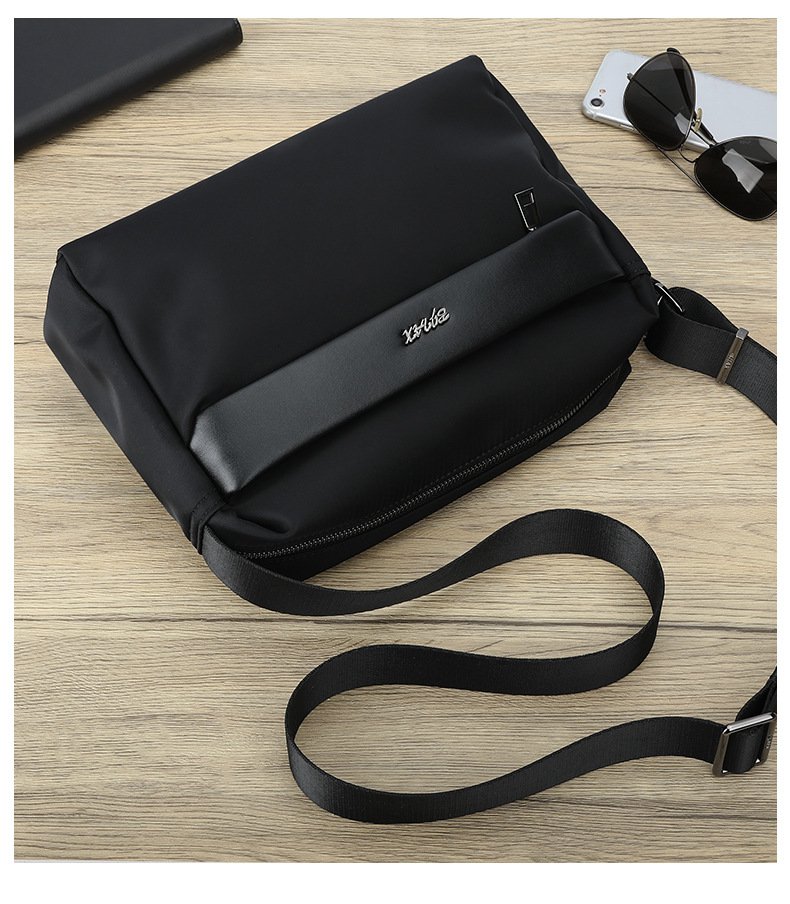 bag resting on gray armchair next to wireless headphones