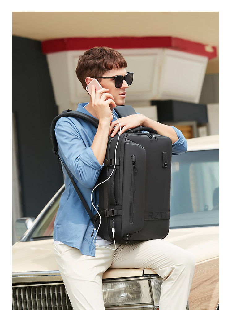 model on a phone call resting the backpack on a car hood